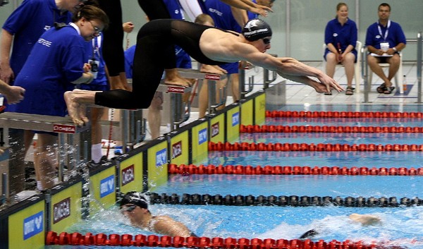 New Zealand's Steve Kent dives in as Glenn Anderson touches the wall during their world record 4 x 50m obstacles relay at the world lifesaving championships in Germany.